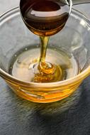Honey pouring in glass bowl