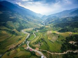 Beautiful landscape of a road among the green and yellow fields and mountains in China