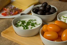 black olives, yellow tomatoes and sour cream sauce on the table