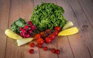 fresh vegetables for salad on a wooden surface