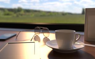 a cup of coffee, glasses and smatrofen on the table against the background of a panoramic window
