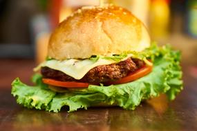 burger with a large leaf of lettuce on the table