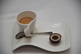 a cup of espresso and a chocolate bar on a saucer