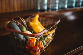 Colorful vegetables in the basket on the wooden table