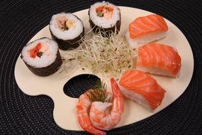 sushi and rolls on a wooden plate in a restaurant