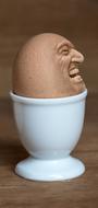 Brown egg, with the face, in the shiny, white cup, clipart