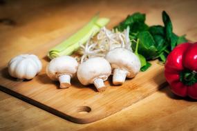 fresh vegetables and mushrooms on a cutting board