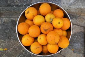 Beautiful, ripe, orange and yellow oranges, in the metal container on Ibiza in Spain