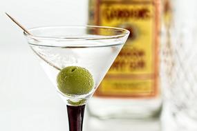 glass with martini and green olive