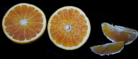 cut oranges on black background