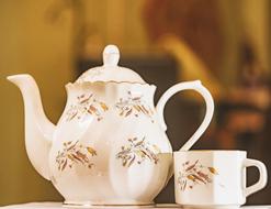 porcelain Teapot and Cup close-up on blurred background