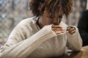 african american woman with a cup of coffee on a blurred background