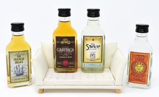 White Men's Sofa with colorful Rum bottles at white background