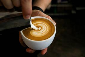 person pouring milk into Coffee