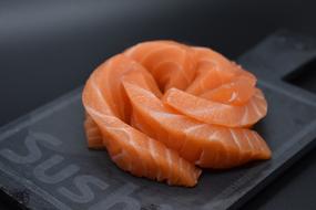 Beautiful Japanese salmon sushi, on the black board with "Sushi" sign