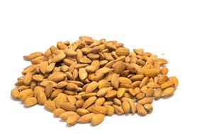 Heap of the dry, brown almonds at white background