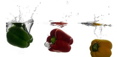 closeup view of three colorful bell peppers drowning in water