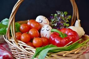 Beautiful and colorful still life with the vegetables and patterned eggs, in the wicker basket