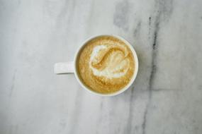 white cup with latte on the table