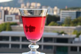 Red drink in the glass at beautiful city view