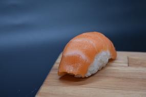 sushi with red fish on a wooden board
