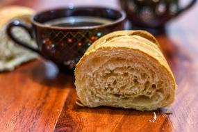 a piece of baguette and a cup of coffee for breakfast