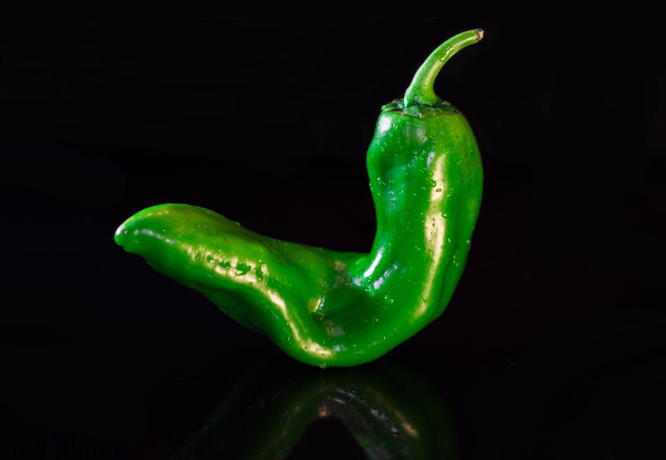 Beautiful, green paprika pepper, with the reflection, at black background