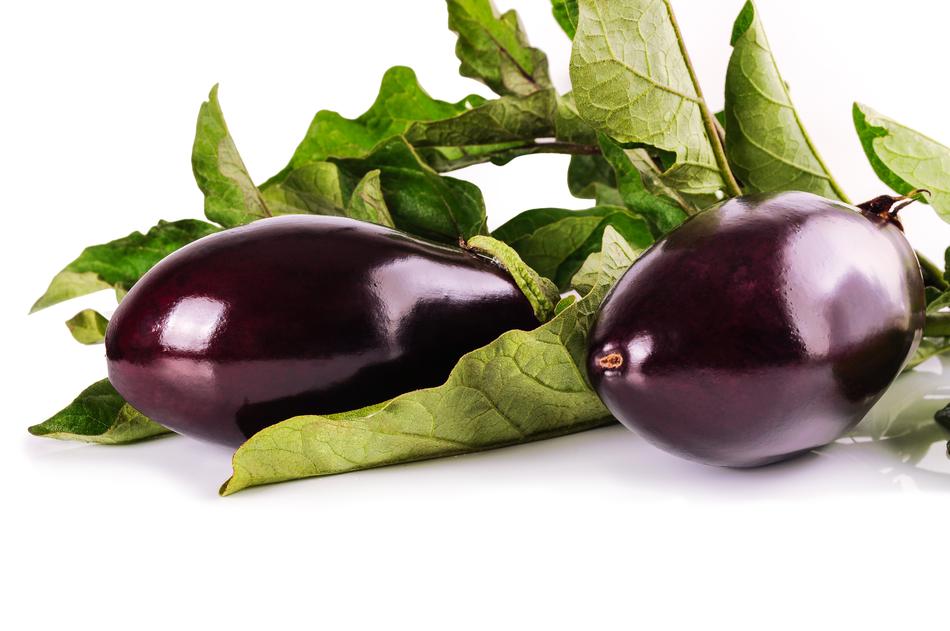 eggplant with green leaves on white