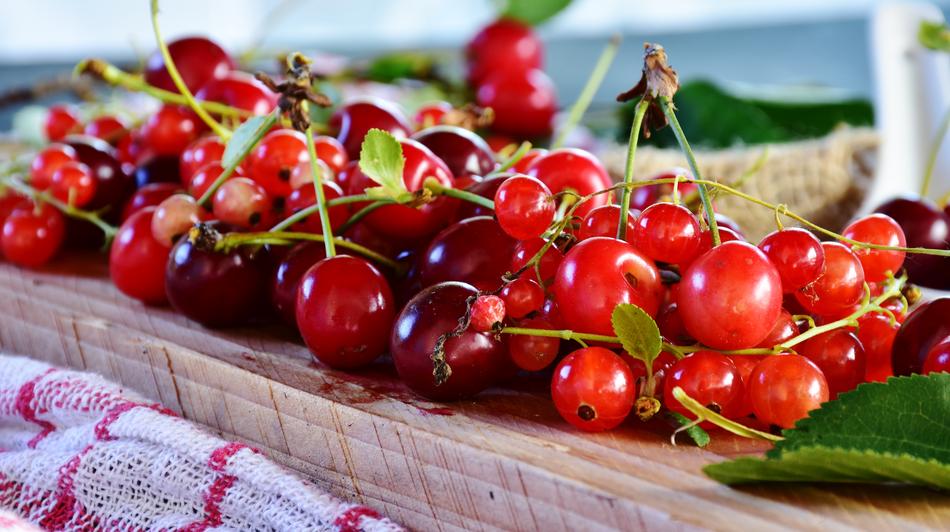 red currants and cherries on a wood board