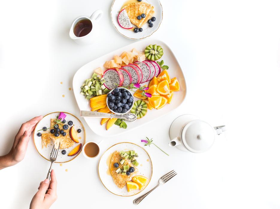 Beautiful and colorful breakfast with fruits and drink, on the white table