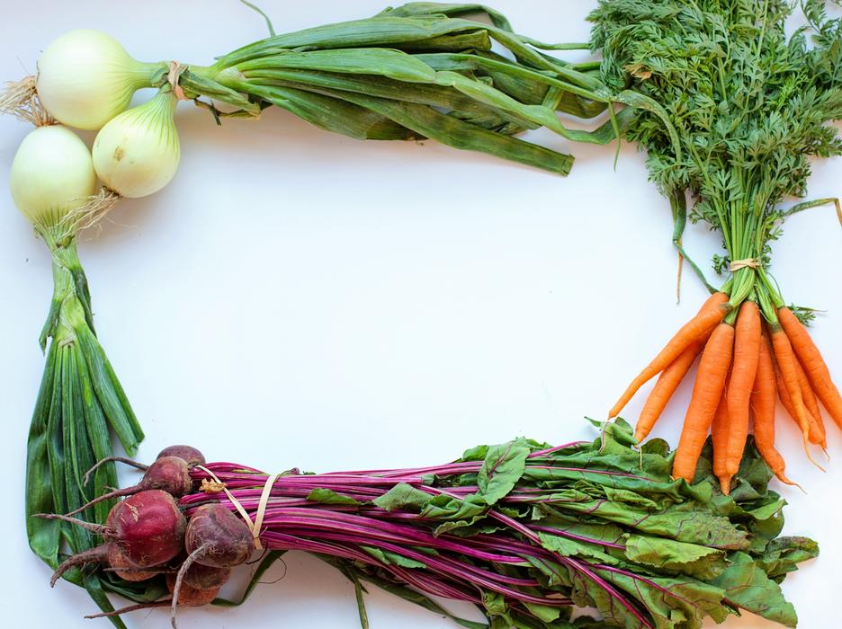 Colorful frame made of onions, beets and carrots at white background