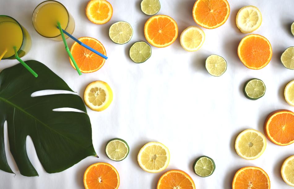 cut Citrus fruits, juice and leaf, background with copy space