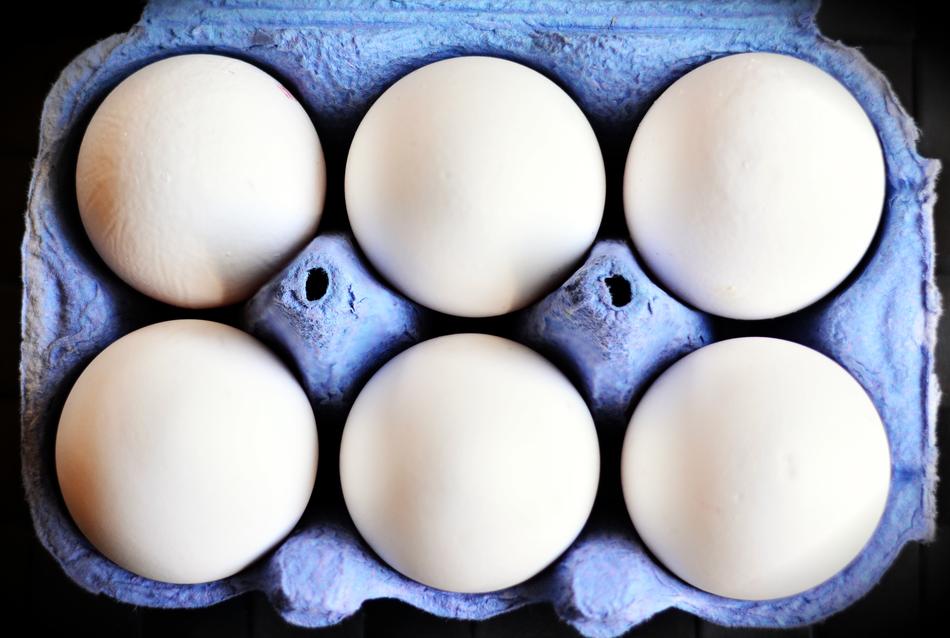 six White Eggs in cardboard box, top view