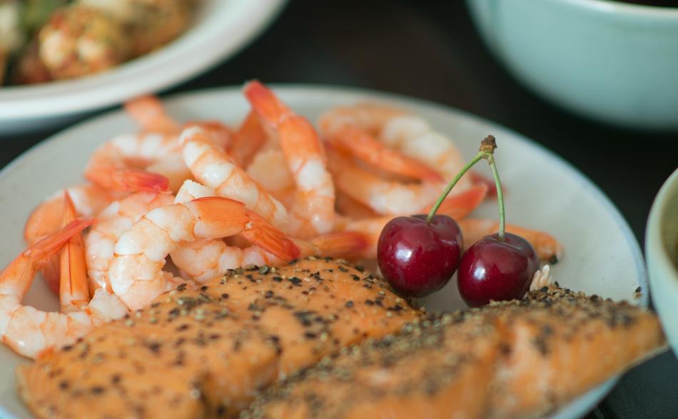 salmon in pepper, shrimp and cherry on a plate