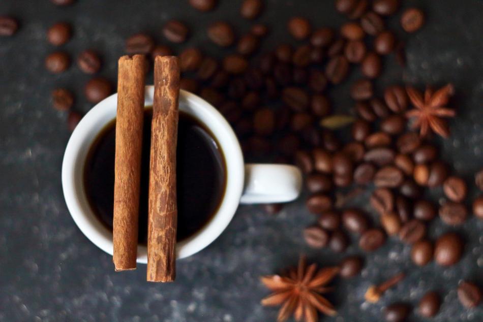 Closeup picture of Coffee in cup with Cinnamon at top and Spices