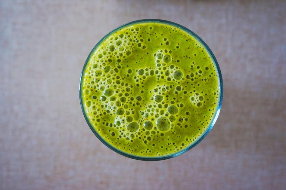 green foamy Smoothie in glass, top view