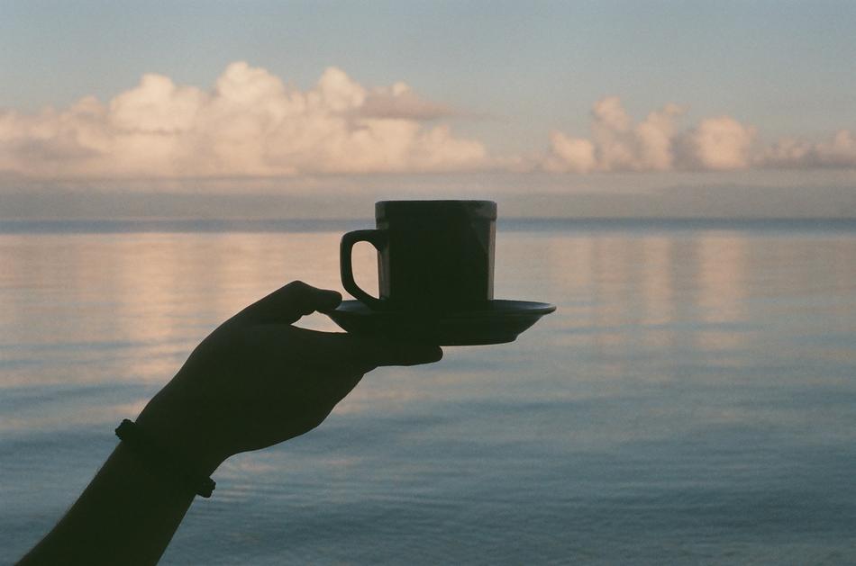 Coffee Cup in hand at calm lake