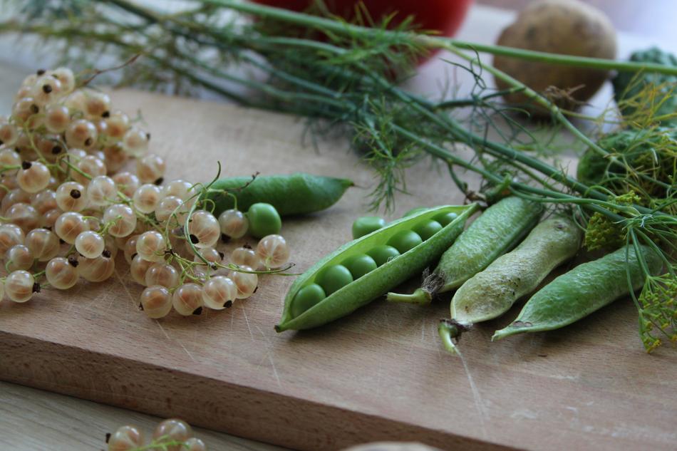 green peas and other vegetables on a cutting board