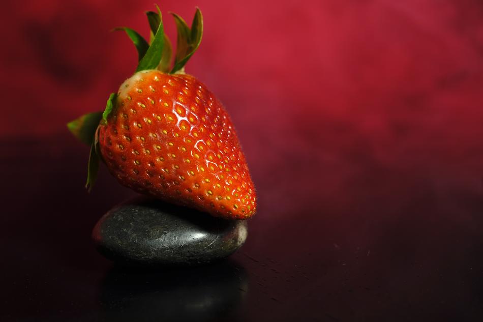 one big Strawberry at foggy red background