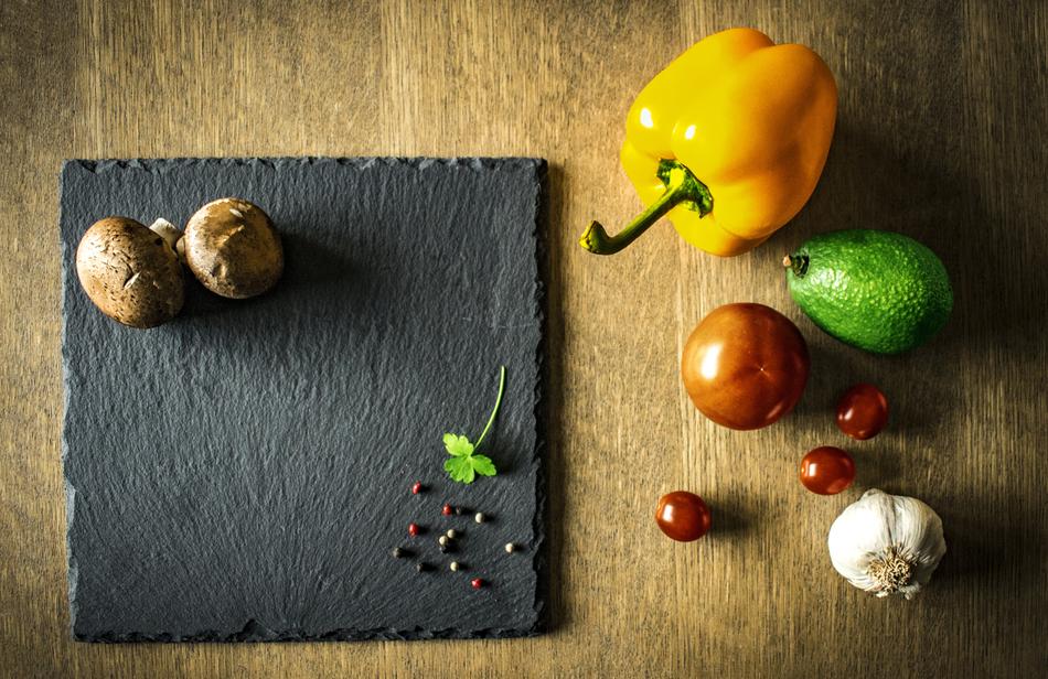 top view of ripe vegetables and spices on a black board on the table
