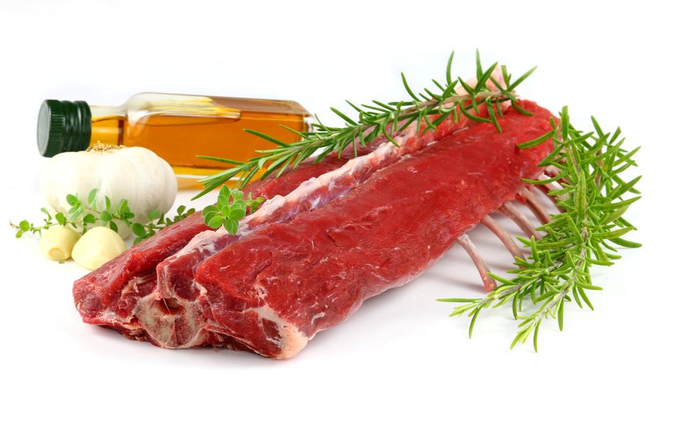 Raw, red lamb Meat, rosemary, garlic and oil on a white surface