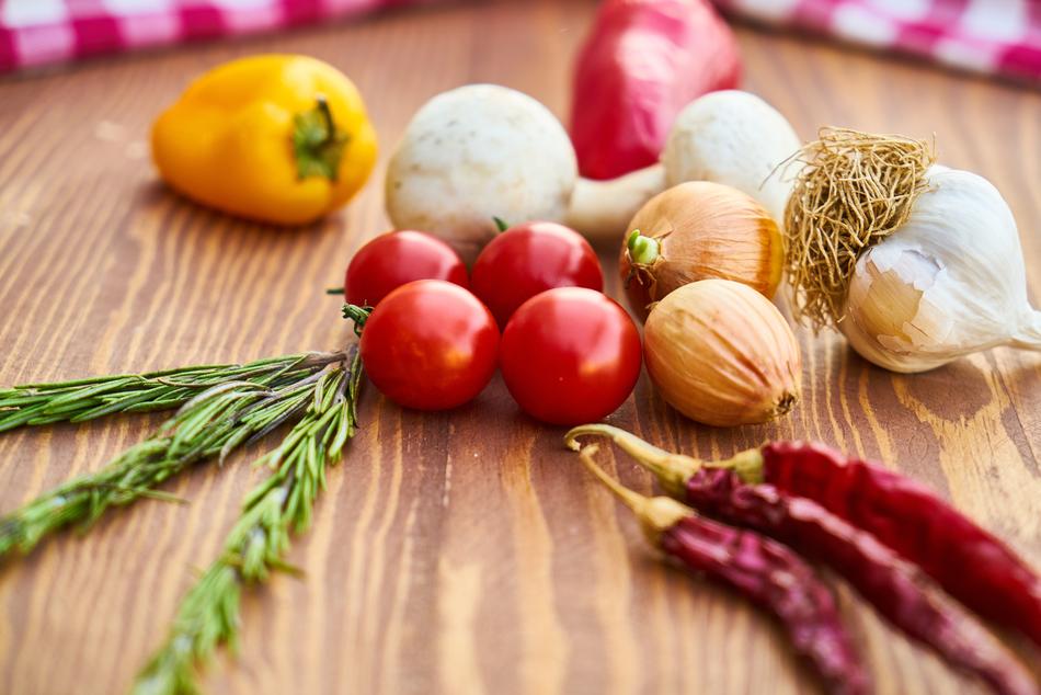 Beautiful and colorful vegetables and herb, on the wooden board, near the colorful clothes