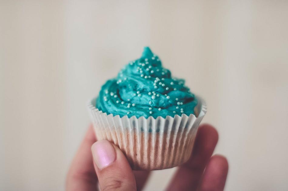 blue cupcake in hand