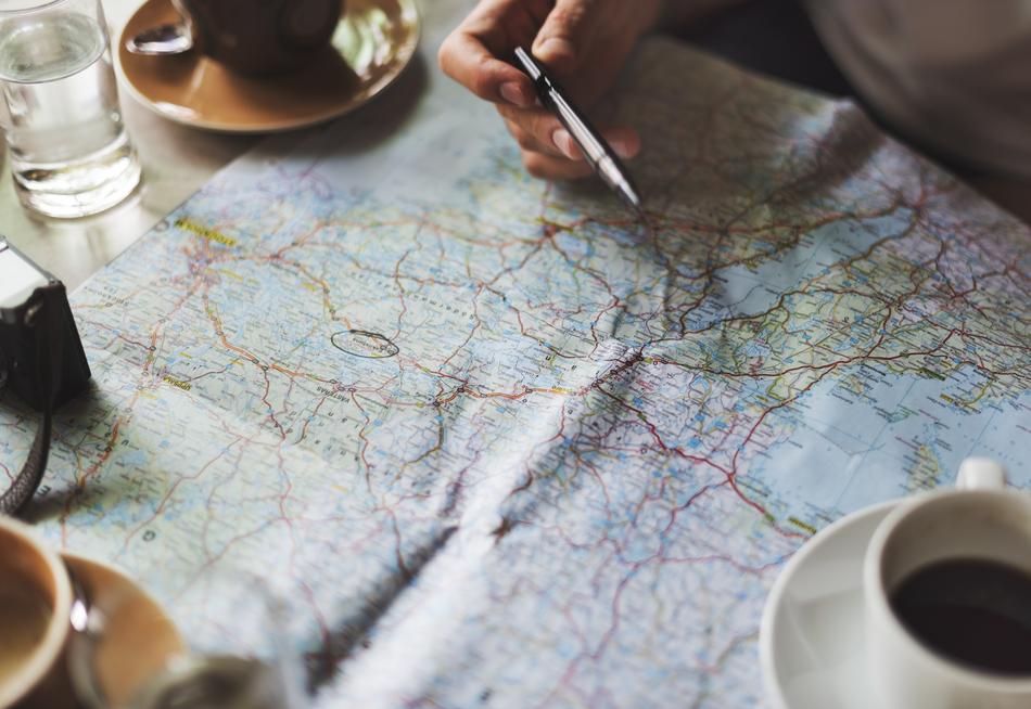 Beautiful and colorful travel map under the cups with coffee