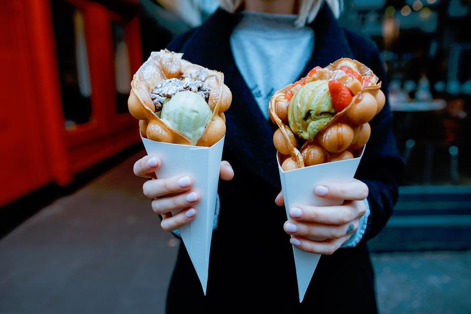 Holding beautiful and colorful gelato cones in hands on the street