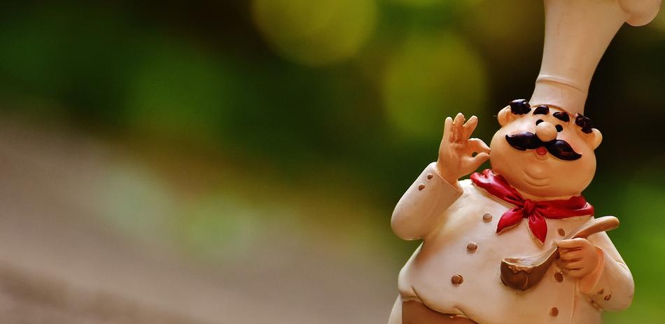 Cute figure of a chef with a scoop at blurred background
