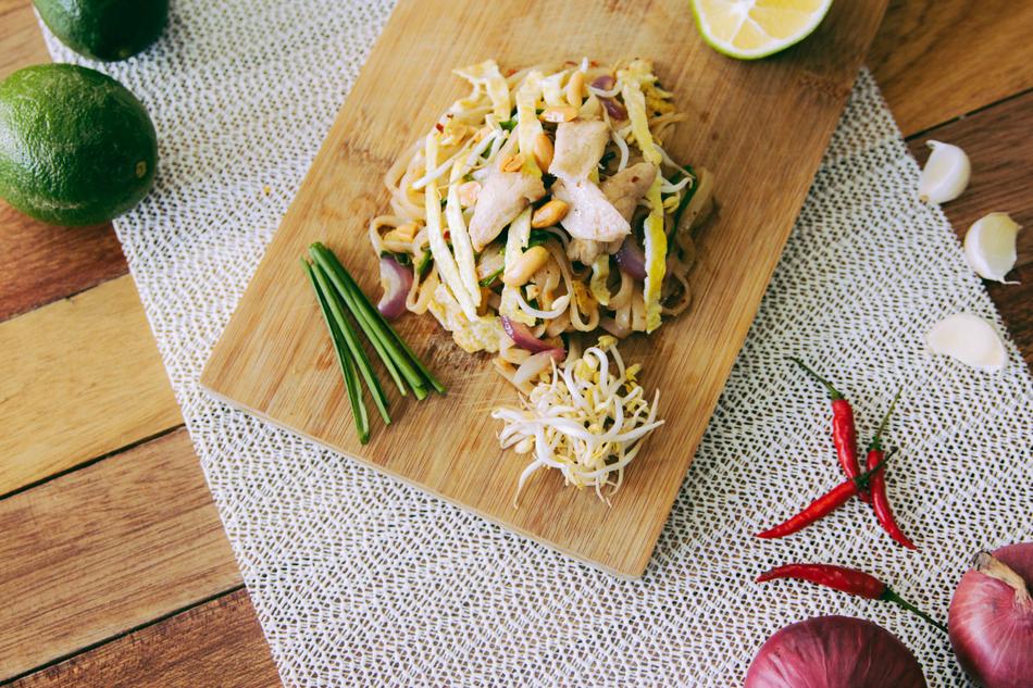 Beautiful noodles with vegetables, served on the wooden cutting board, with fruits and vegetables