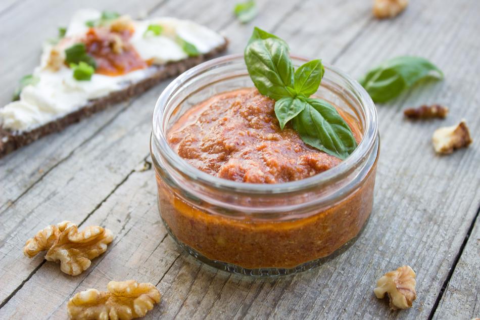 Beautiful, red pesto with tomatoes, basil, walnuts and parmesan in the glass bowl