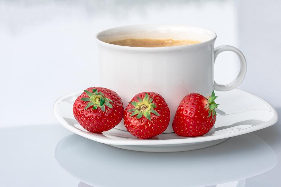 cup of coffee and ripe strawberries