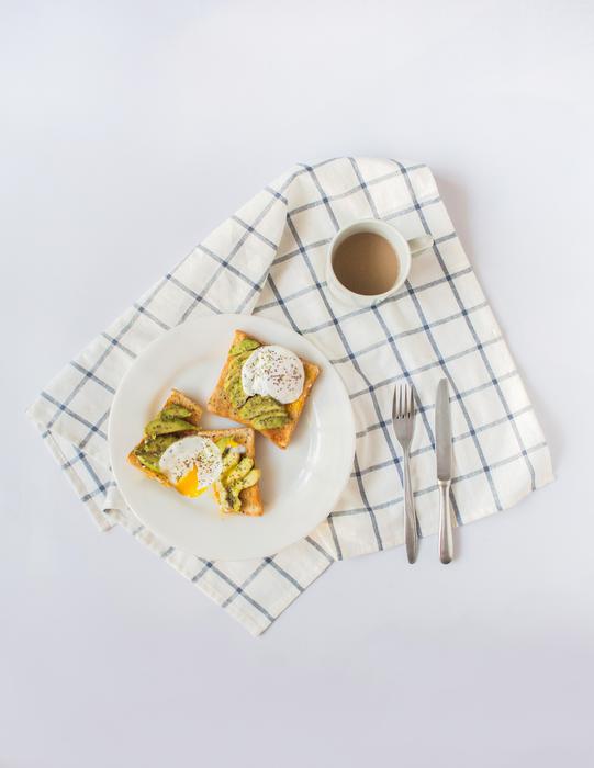 Beautiful and colorful breakfast on the plate, cup of coffee and cutlery on the checkered cloth